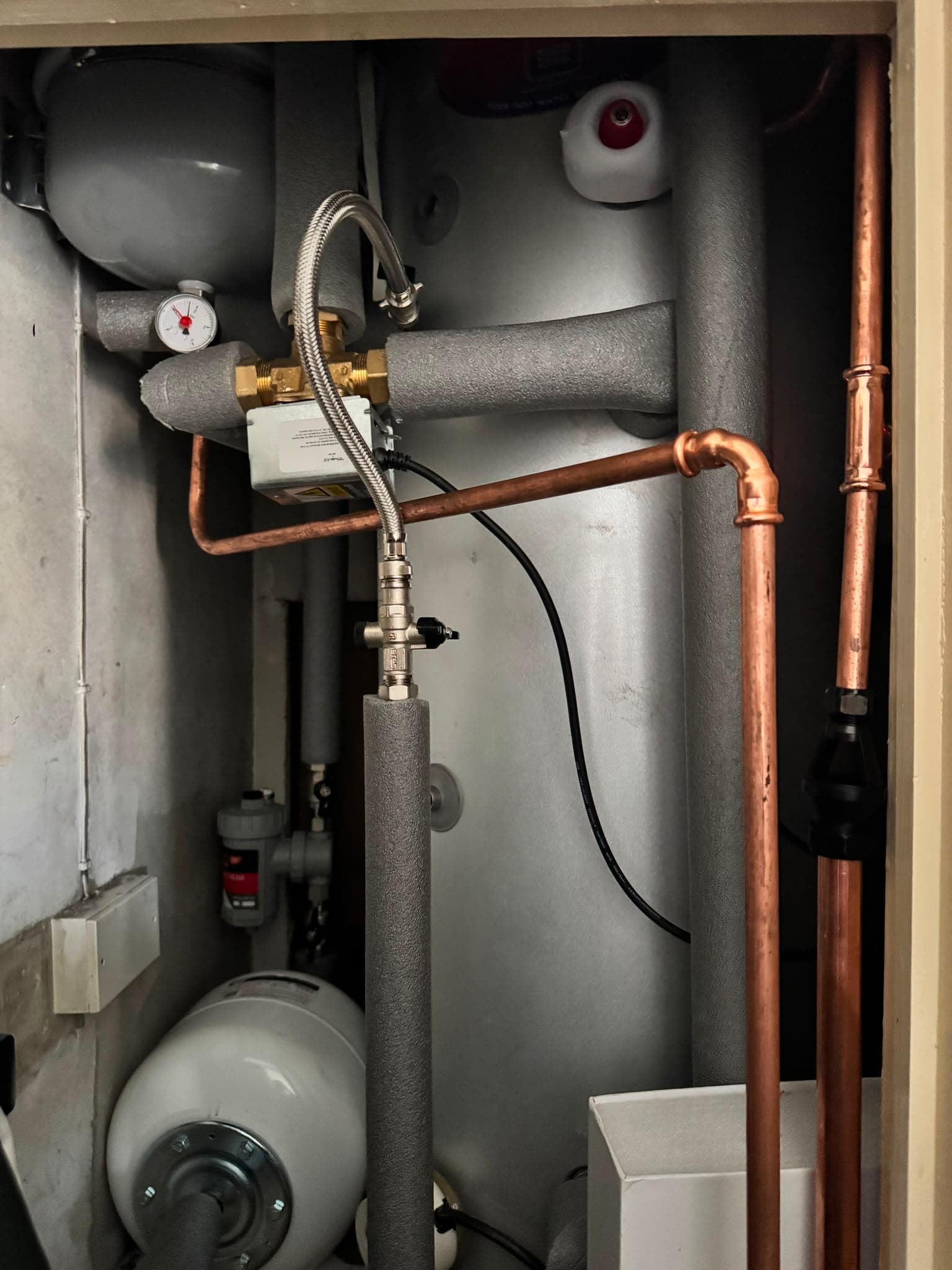 New unvented hot water cylinder cupboard with fully insulated pipework, expansion vessels and blending valve