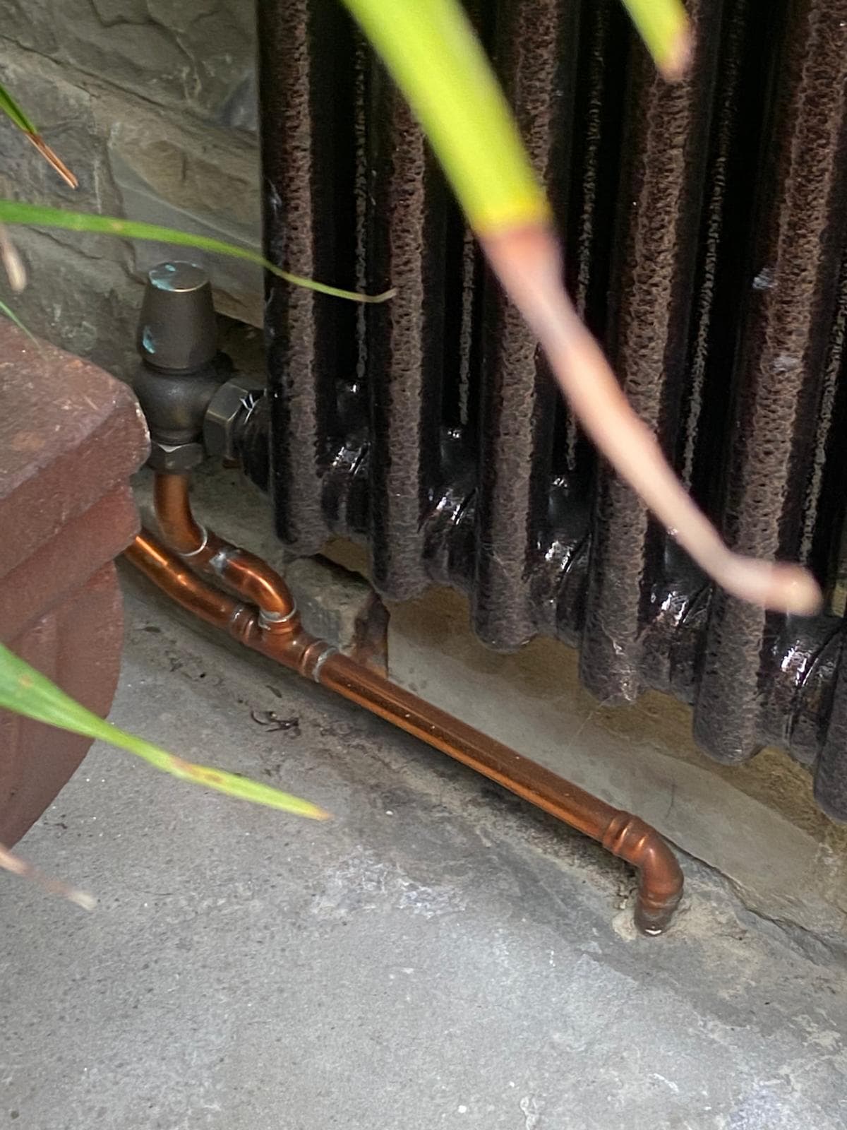 Copper pipework and traditional valve beneath a cast iron column radiator