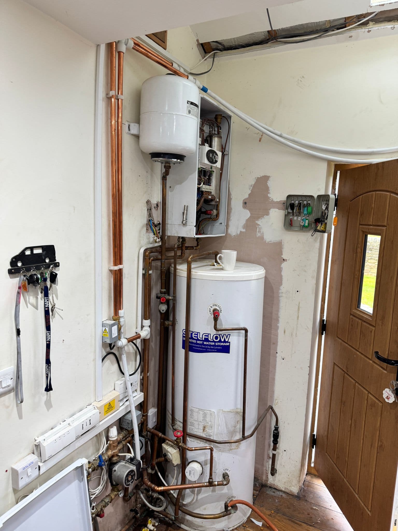 Electric boiler and hot water cylinder relocated and re-piped in a utility cupboard