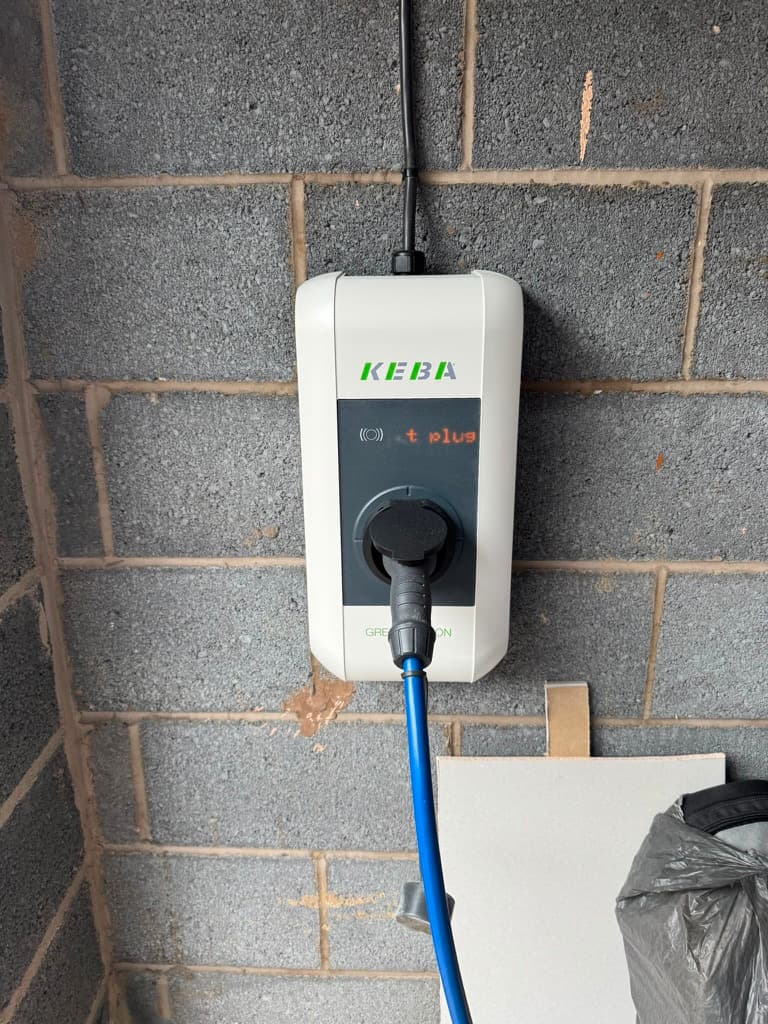 KEBA Green Edition EV charger wall box installed in a garage and charging a vehicle