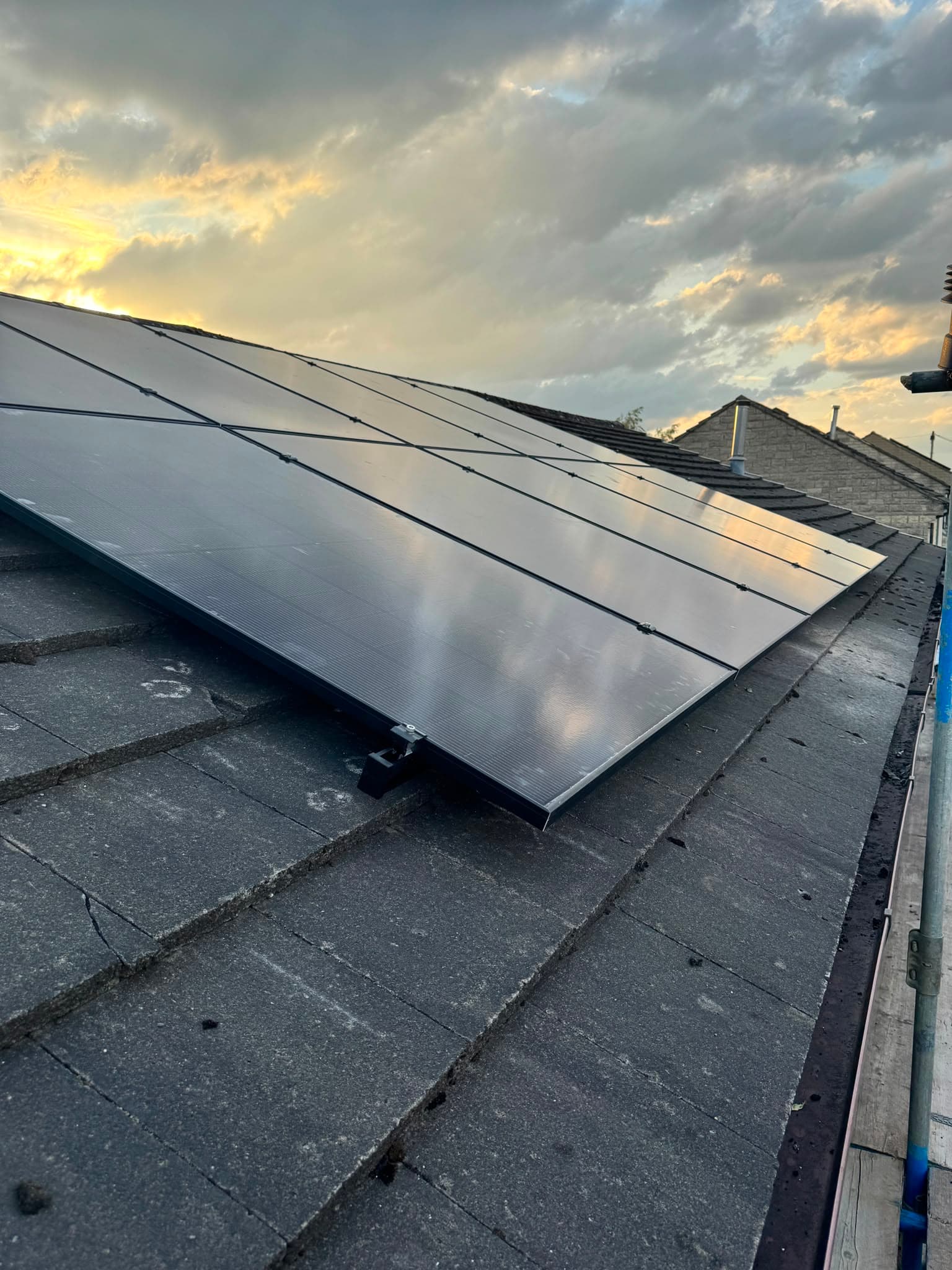Wide view of the solar panel array mounted on a residential roof with scaffolding