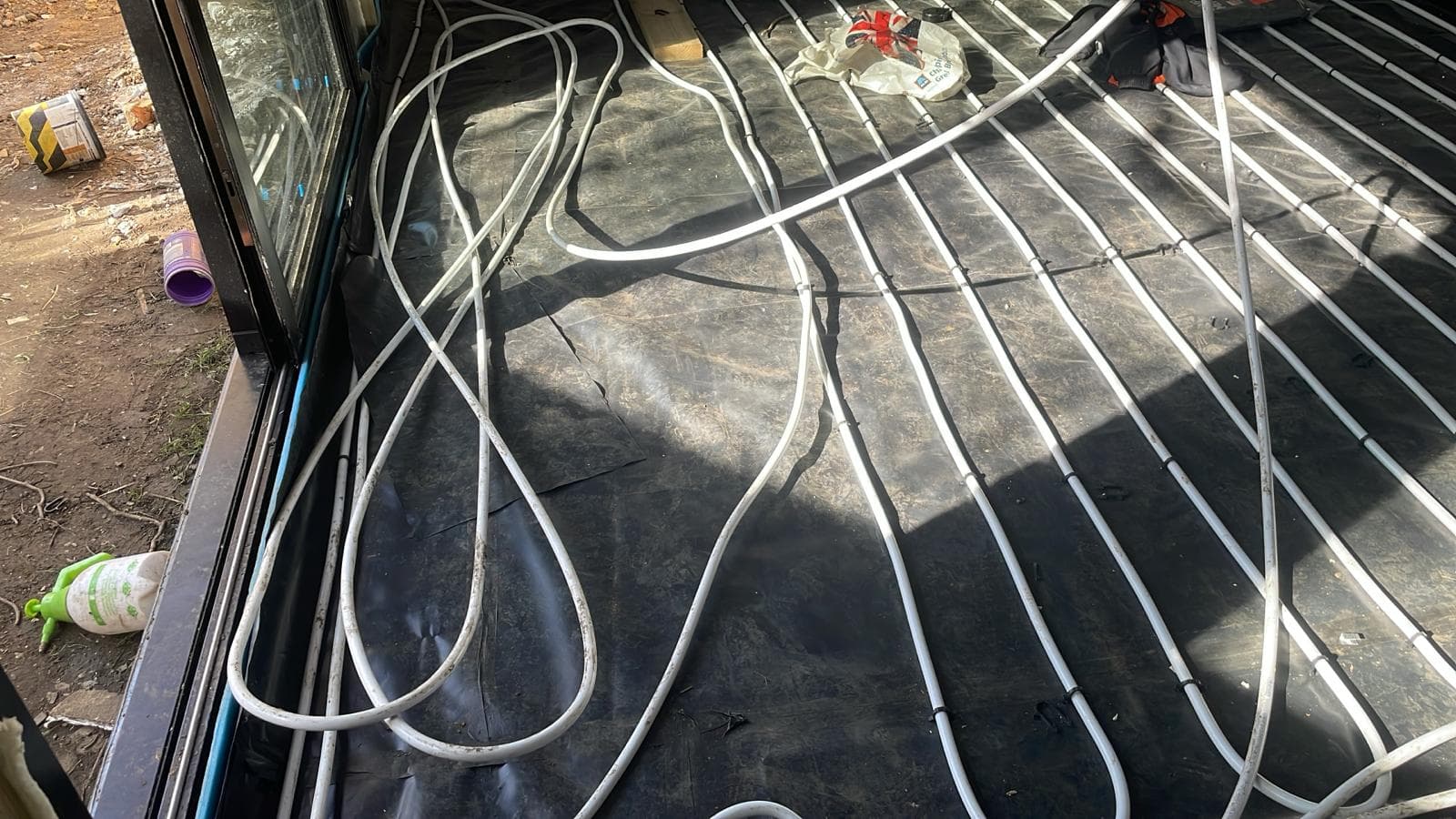 Underfloor heating pipe laid in clipped rows over the membrane in a new extension