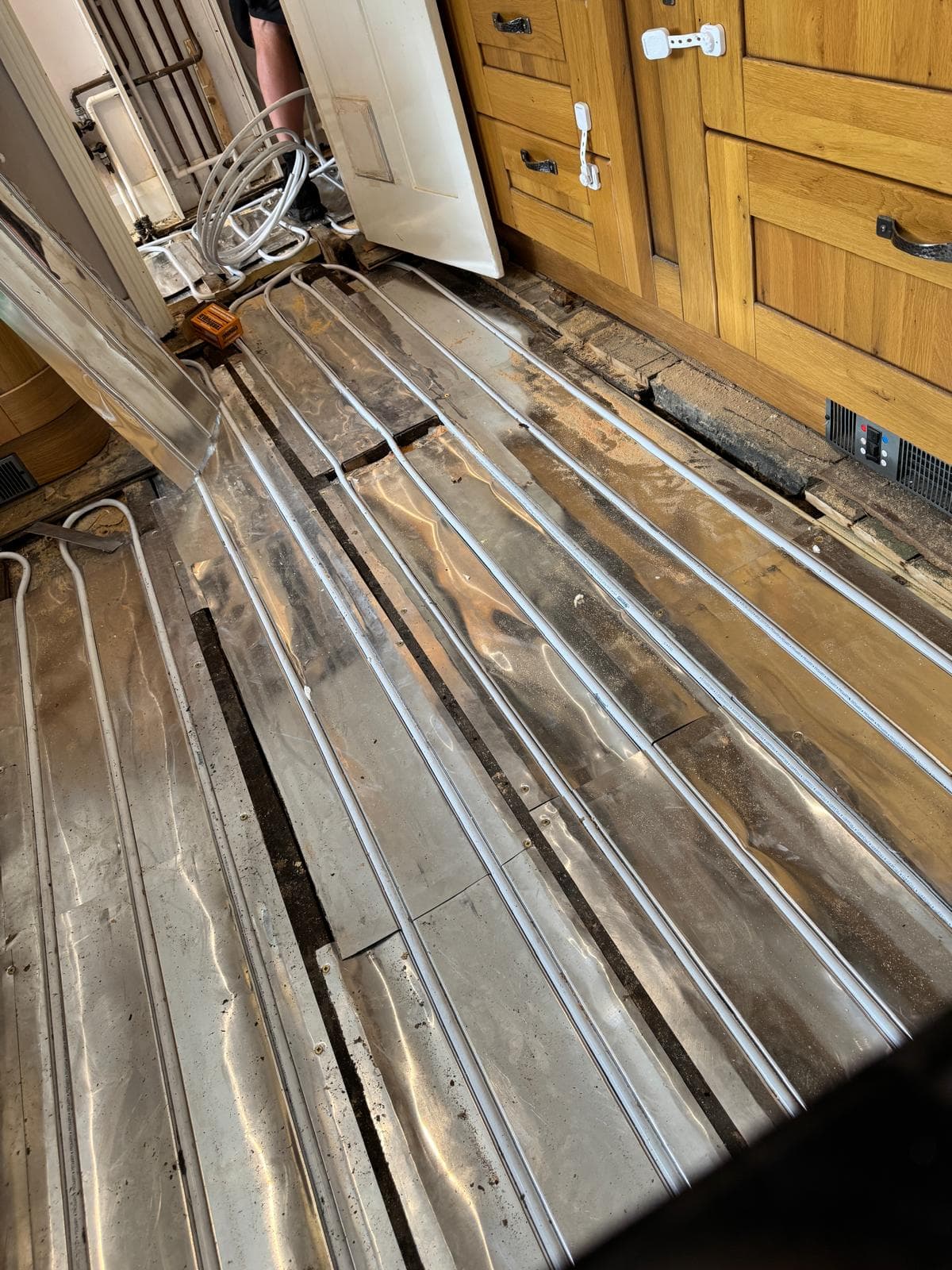 Long straight runs of underfloor heating pipe in spreader plates across the kitchen floor
