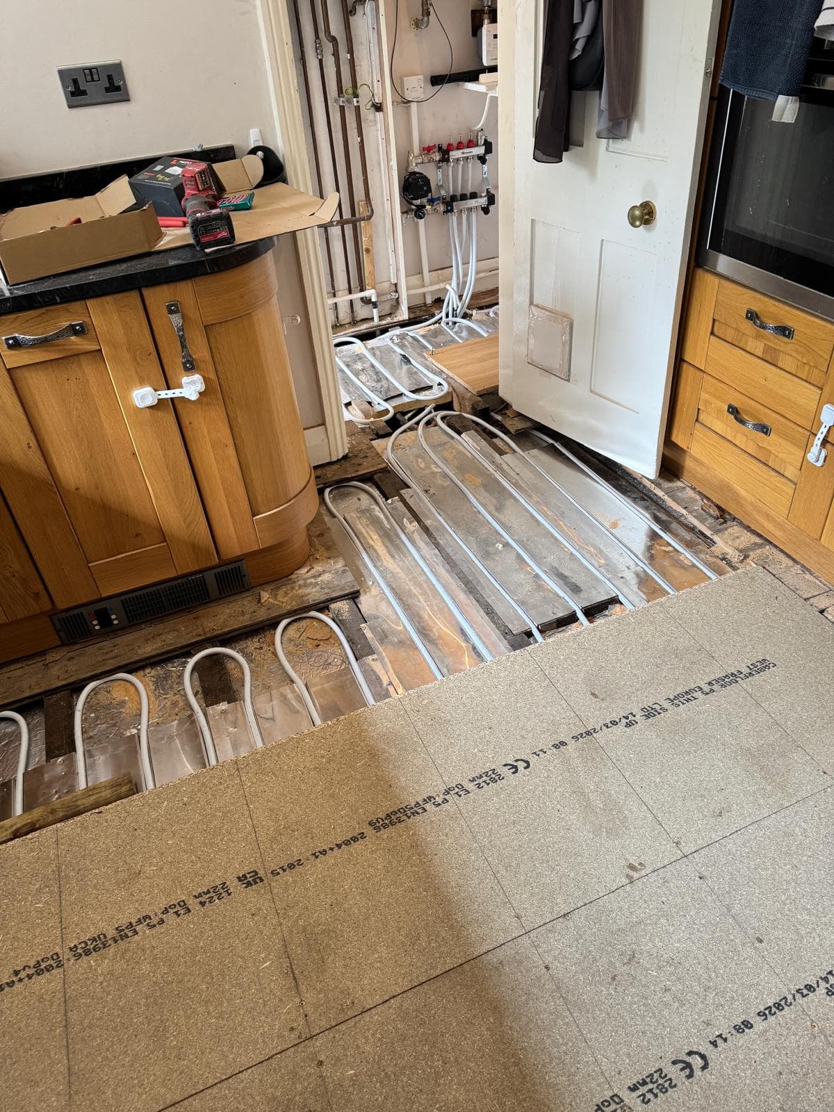 Chipboard flooring being fitted back over the underfloor heating spreader plates